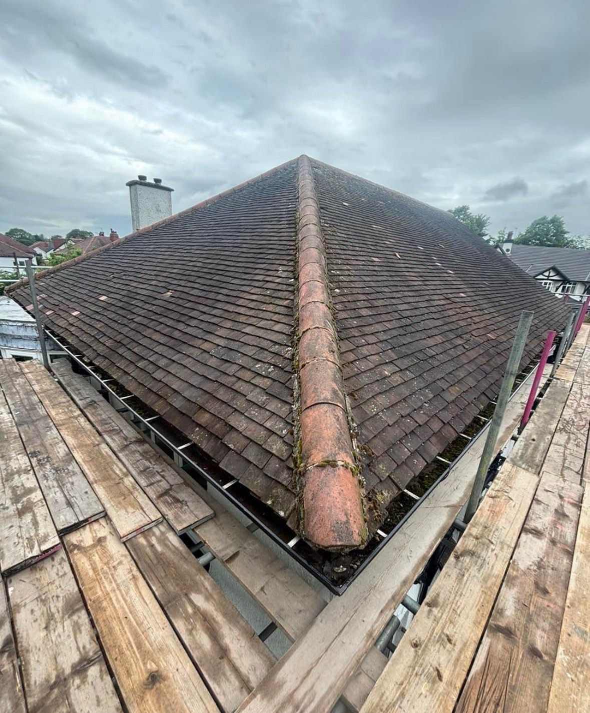 Heavy moss growth across a tiled roof hip before professional roof moss removal in Teesside