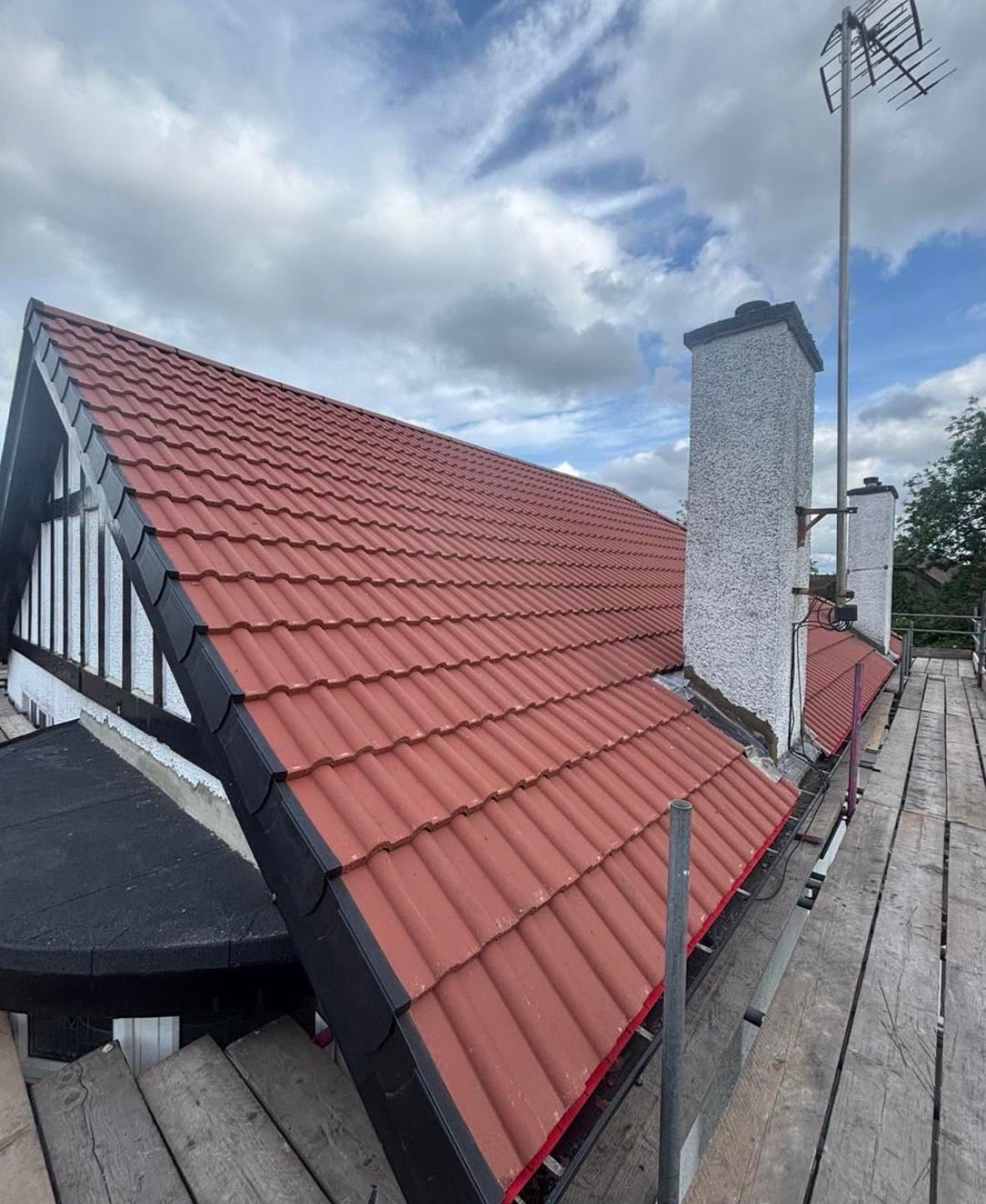 Black dry verge caps and dry ridge system fitted to a red tiled roof in Yarm